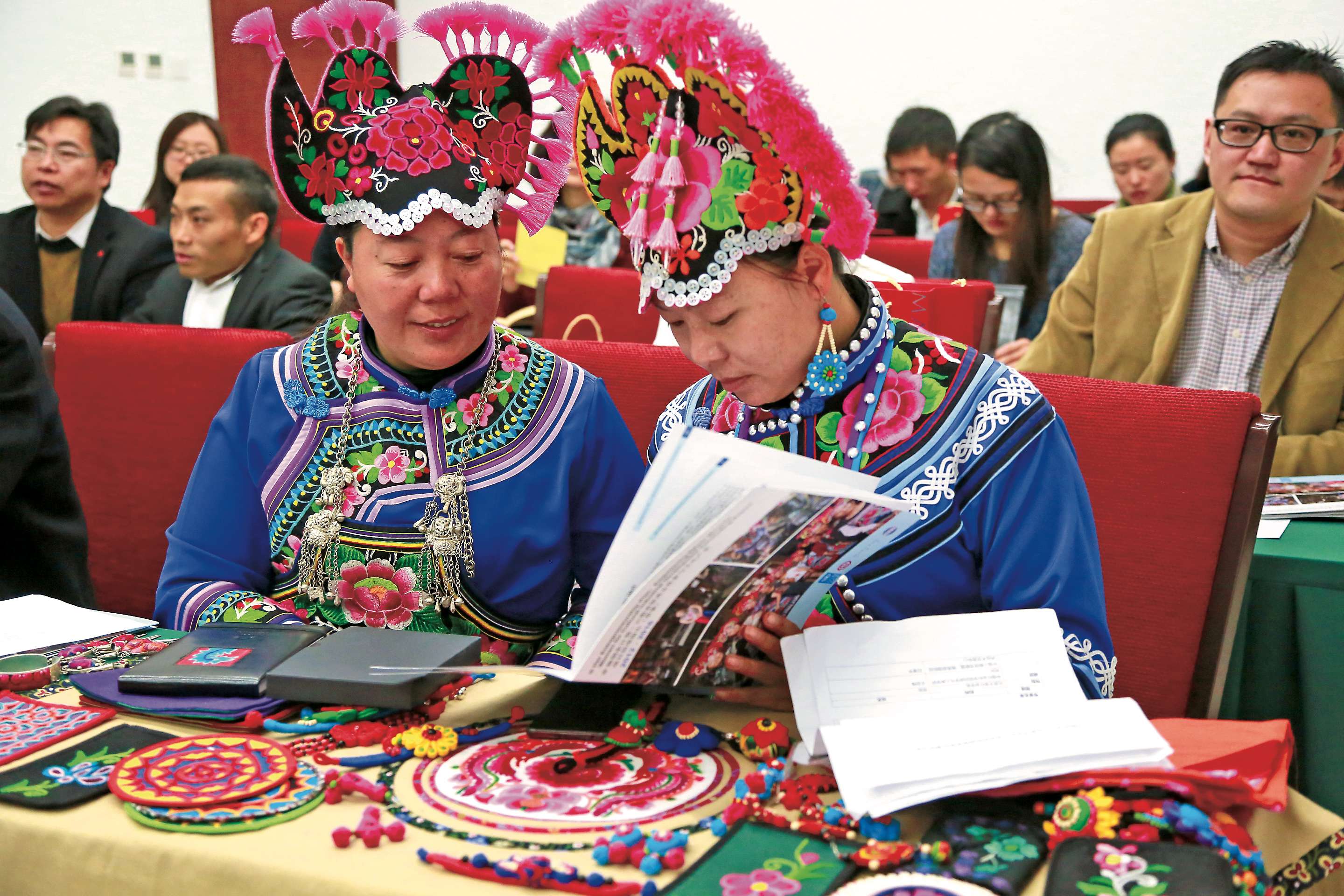 楚雄州两名彝族女性在看普通话编写的商品手册，她们正参加文化产业发展项目.jpg